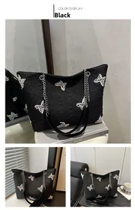 Macro detail of black tote bag with color butterfly embroidery and metal chain strap