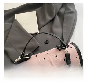 Detail der rosa zylindrischen Handtasche mit Herzmustern und silbernem Bogendekor