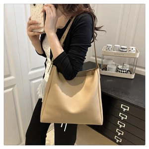 Close-up of wide shoulder strap on light brown faux leather tote bag for daily commute