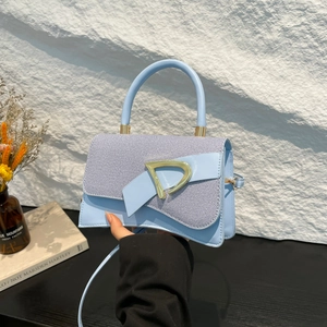 Light blue crossbody handbag with denim texture flap and large gold metal buckle
