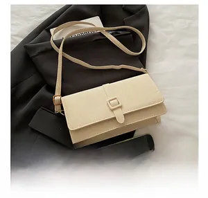 Size comparison of a beige flap crossbody bag with a smartphone showing compact capacity