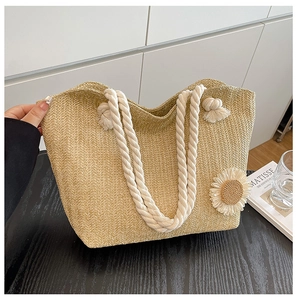 Detail of hand-held straw tote bag with cotton rope handles and white sunflower decor
