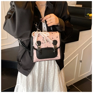 Détail du sac à dos plissé rose avec dentelle, perles et imprimés nœuds noirs élégants