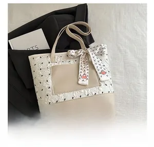 Détail du sac fourre-tout matelassé blanc crème avec nœud en soie et décor de veste noire