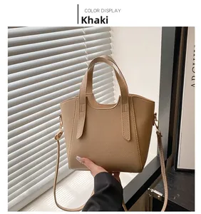 Dettaglio della borsa a secchiello in pelle kaki con trama litchi e inserti in metallo