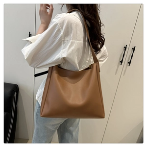 Minimalist caramel brown leather tote bag worn by a model for a chic commute style