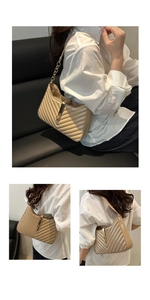 Detail of beige quilted faux leather shoulder bag with gold hardware lock and chain strap