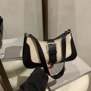 Minimalist beige canvas crescent bag with black leather trim and silver square buckle