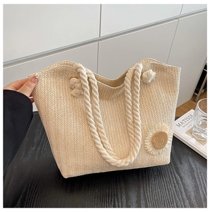 Close-up of woven tote bag with cotton rope handles and sunflower applique detail