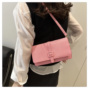 Détail du sac à bandoulière rose rectangulaire avec texture tissée et boucle décorative carrée