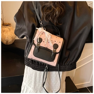 Détail du sac à dos plissé rose et noir avec nœuds en dentelle et chaîne de perles