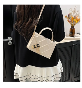 Quilted diamond pattern crossbody bag with gold lock and chain on model's back