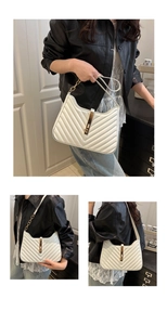 Close-up of a white quilted crossbody bag with golden hardware and chain strap details
