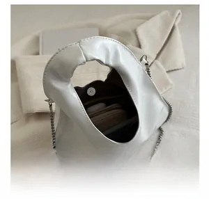 Interior capacity of white cloud handbag showing space for wallet and earphones