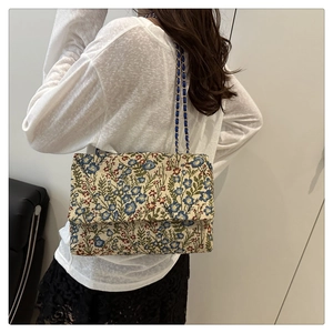 Floral brocade shoulder bag with chain strap shown on model for a vintage look