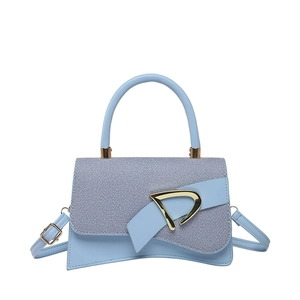 Fashionable light blue hourglass bag with chic patchwork flap and golden D-buckle detail