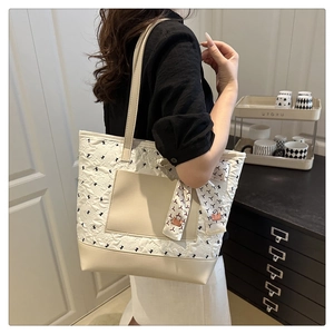 Quilted tote bag detail with printed silk scarf and leather shoulder strap on the side