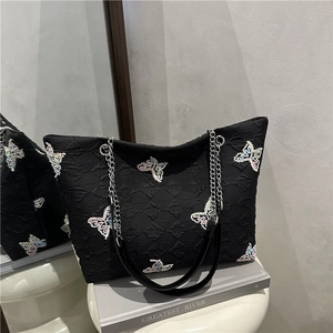 Minimalist black tote bag featuring textured fabric with colorful sequin butterfly embroidery
