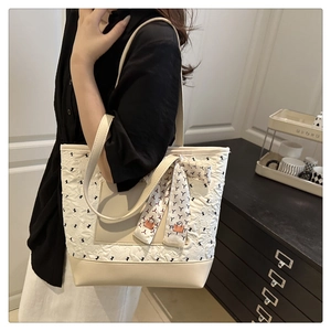 Gros plan du sac cabas beige matelassé avec détails imprimés et foulard en soie décoratif