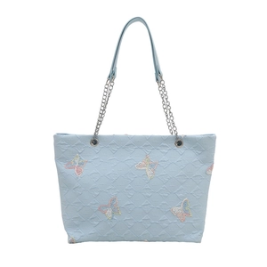 Light blue quilted tote bag with butterfly patterns and silver chain shoulder strap