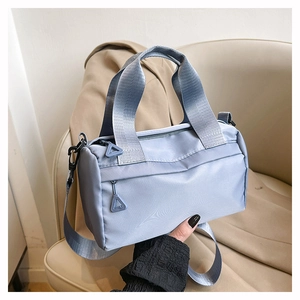 Détail du mini sac oreiller en nylon bleu clair avec poignées et tirette triangulaire