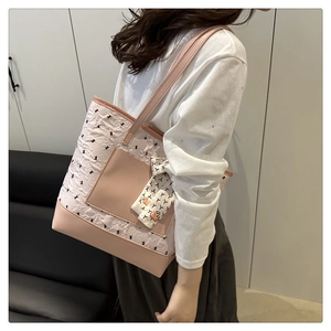 Detail of pink floral tote bag with bow pattern shown on model for size and style
