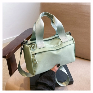 Détail du sac polochon en nylon vert menthe avec bandoulière amovible et fermeture