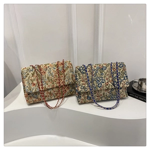 Close-up of intricate floral embroidery and leather chain straps on stylish shoulder bags