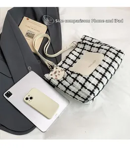 Flat lay of plaid tote bag showing size comparison with tablet and leather front pocket