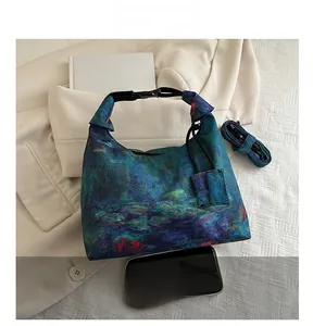 Detail view of Monet oil painting floral bucket bag with size comparison to smartphone