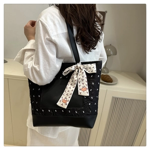 Vue détaillée du sac cabas matelassé noir avec foulard en soie sur la poignée élégante