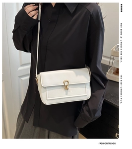 Detail of white rectangle leather bag with gold buckle and adjustable strap
