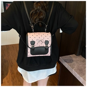 Vue mannequin du mini sac à dos rose et noir avec motifs de cœurs et boucle de nœud en métal