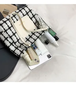 Detail of checkered tote bag interior capacity with leather pocket and tablet storage