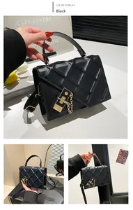 Detail of black quilted crossbody bag featuring a gold twist lock and metallic chain strap