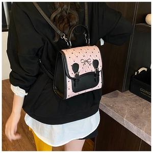 Détail du sac rose embossé de cœurs avec boucle nœud argenté sur le modèle