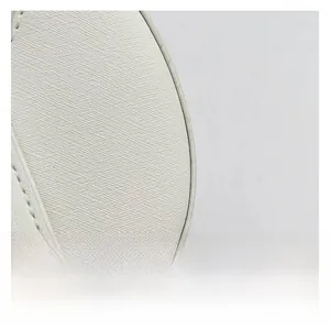 Primer plano detallado del bolso blanco con cuero de grano cruzado y costuras de precisión