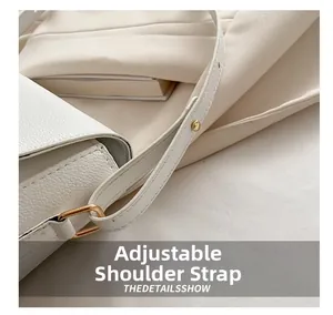 Detail of adjustable strap with gold buckles on a white lychee leather handbag