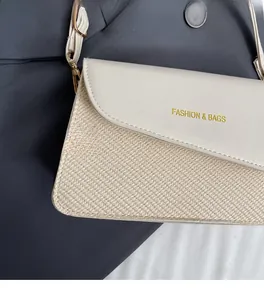 Close-up of cream leather and straw woven crossbody bag with gold fashion logo