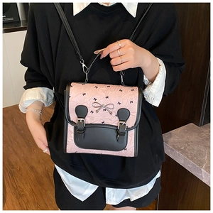 Détail du sac bandoulière tendance avec motifs de nœuds noirs et boucle de nœud argenté