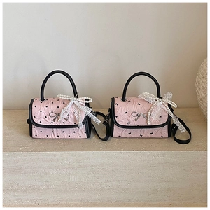 Detail of pink pleated mini bags with black bow and heart prints plus pearl charms