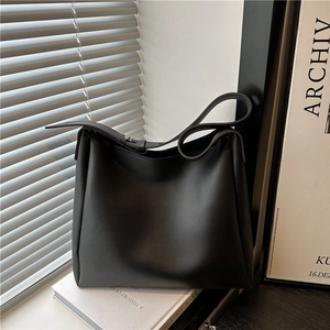 Minimalist black matte tote bag with adjustable strap in a lifestyle window setting