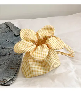 Close-up of yellow and white gingham drawstring bucket bag with petal-shaped top