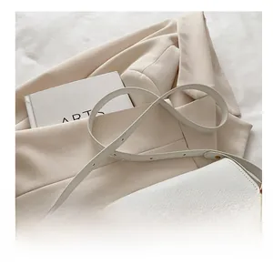 Detailed macro view of white lychee pattern leather texture and gold hardware clasp