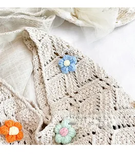Detail of crochet bucket bag featuring 3D floral accents and hollow knit texture