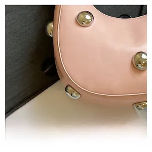 Detail der rosa Lederhandtasche mit polierten Silbernieten und feiner Texturierung
