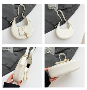 Detalle del bolso media luna blanco con cuero textura litchi y logo de borla dorada