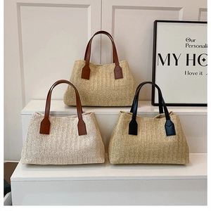 Handwoven straw tote bags with faux leather handles in a minimalist studio setting