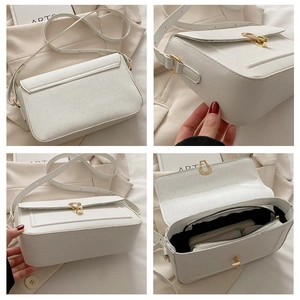 Detail view of white lychee leather handbag featuring a gold twist lock and interior pocket