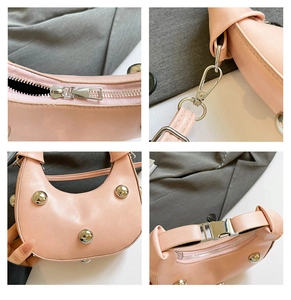 Detailansicht der rosa Halbmondtasche mit Silbernieten, Glattleder und Metallbeschlägen